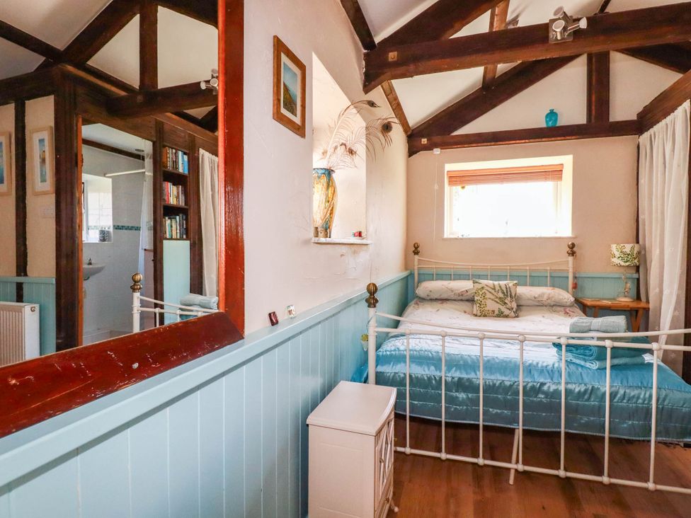A bedroom with a bed and a nightstand at The Jingle House in Tregony