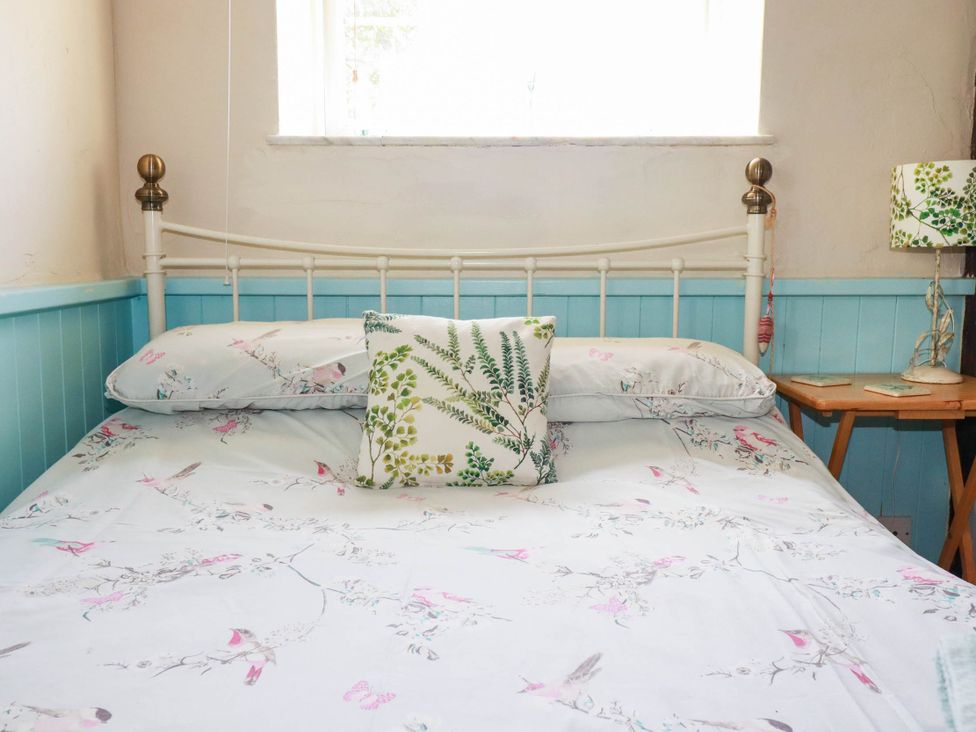 A bedroom with a bed and window at The Jingle House in Tregony