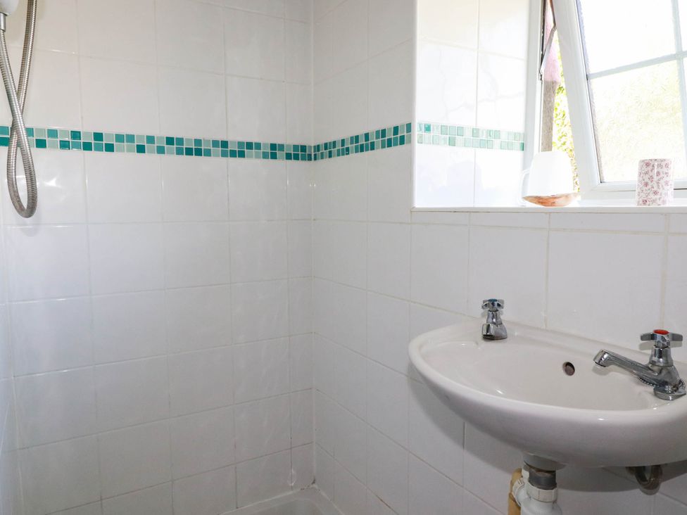 A bathroom with a shower and sink at The Jingle House in Tregony