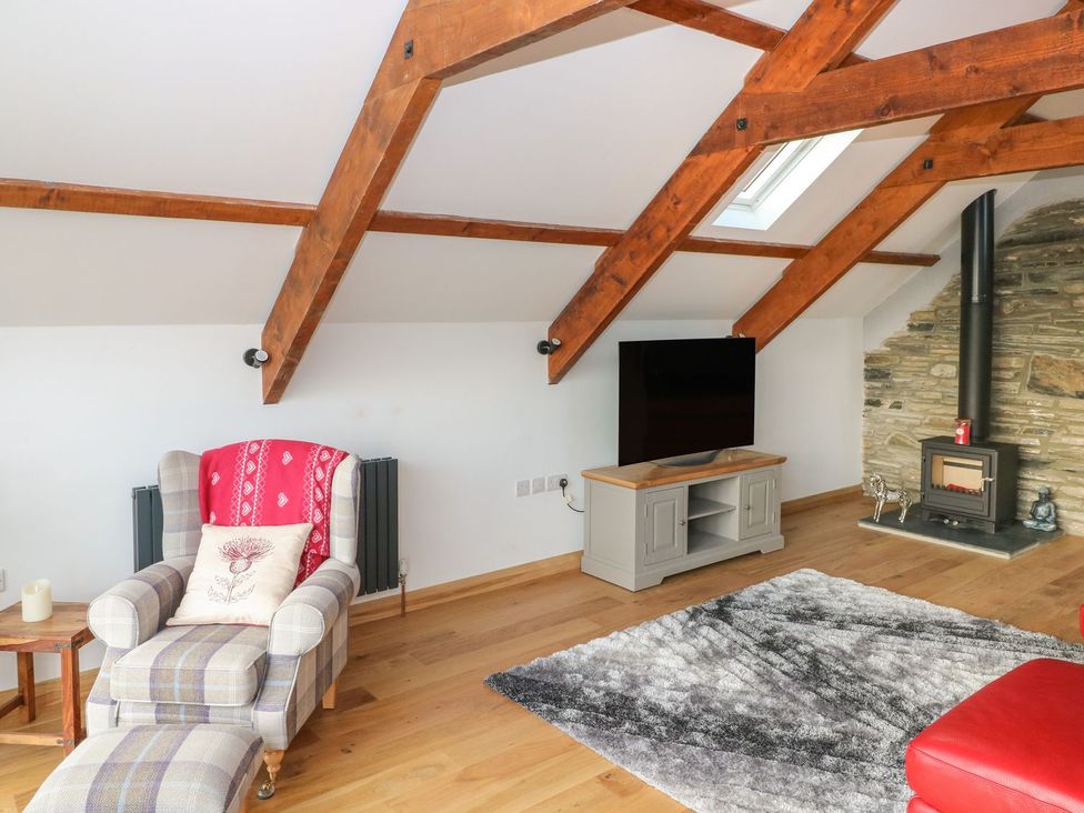 A living room with an armchair and television at The Cartbarn at Cadwgan Farm near Whitland
