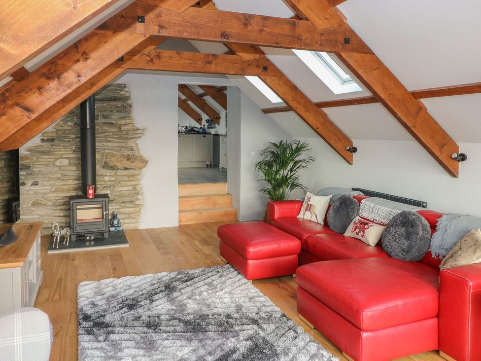 A living room with a red sofa and fireplace at The Cartbarn at Cadwgan Farm near Whitland