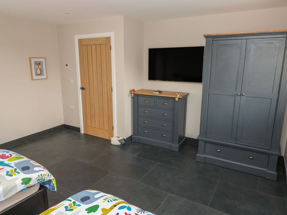A bedroom with a wardrobe and a television at The Cartbarn at Cadwgan Farm near Whitland
