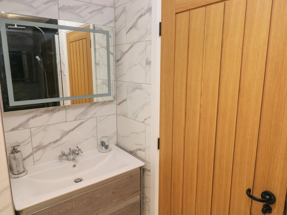 A bathroom with a sink and mirror at The Cartbarn at Cadwgan Farm near Whitland