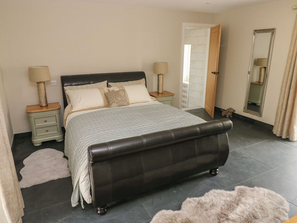 A bedroom with a bed and nightstands at The Cartbarn at Cadwgan Farm near Whitland
