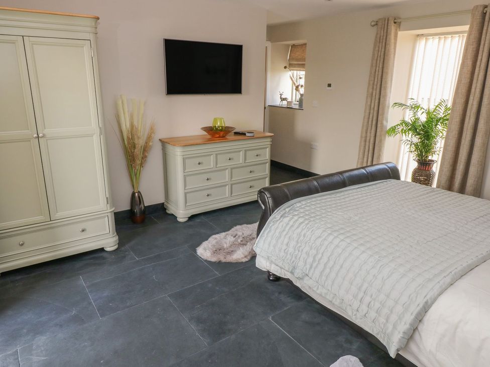 A bedroom with a bed and wardrobe at The Cartbarn at Cadwgan Farm near Whitland