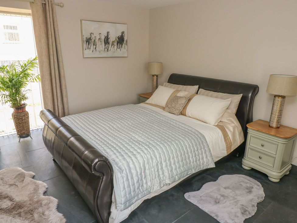 A bedroom with a bed and bedside table at The Cartbarn at Cadwgan Farm near Whitland