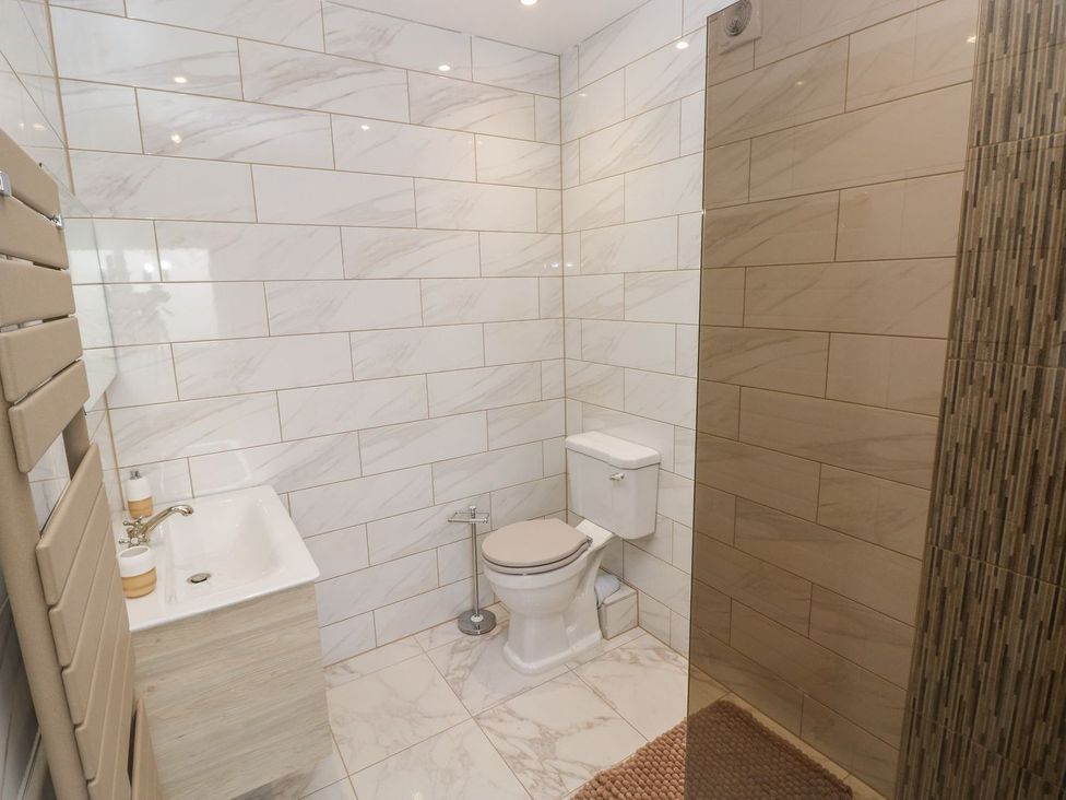 A bathroom with a toilet, shower, and sink at The Cartbarn at Cadwgan Farm near Whitland