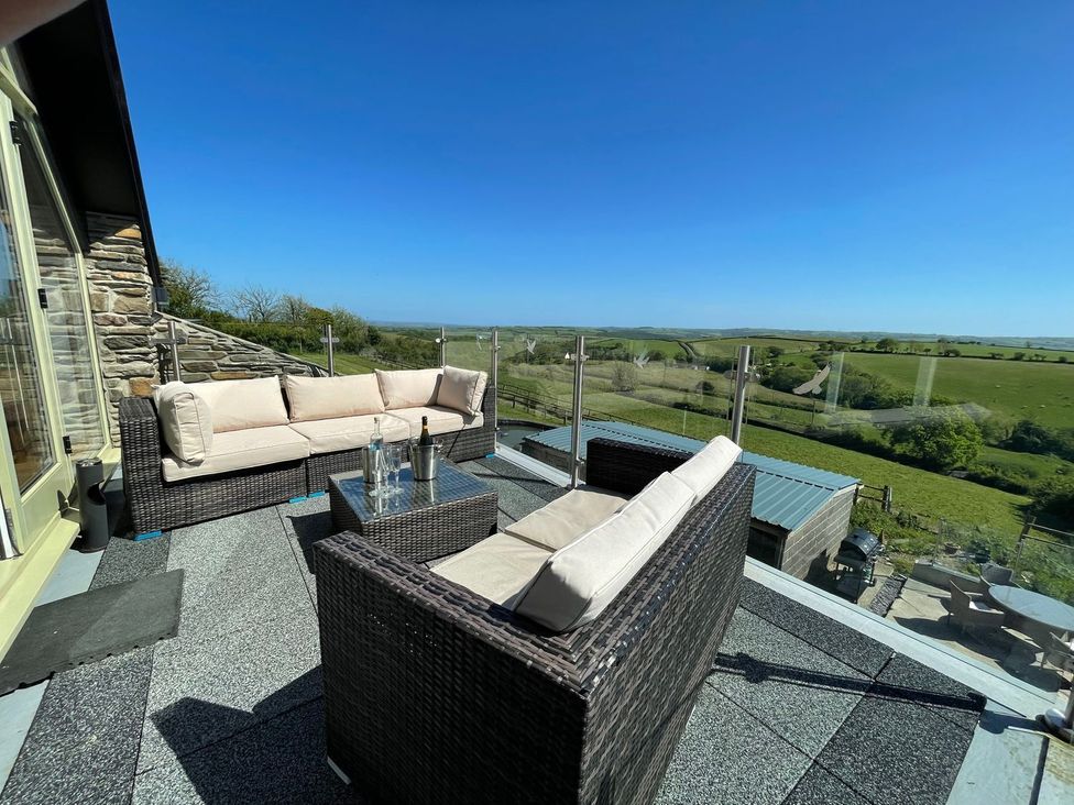 An outdoor patio with seating and a view at The Cartbarn at Cadwgan Farm near Whitland