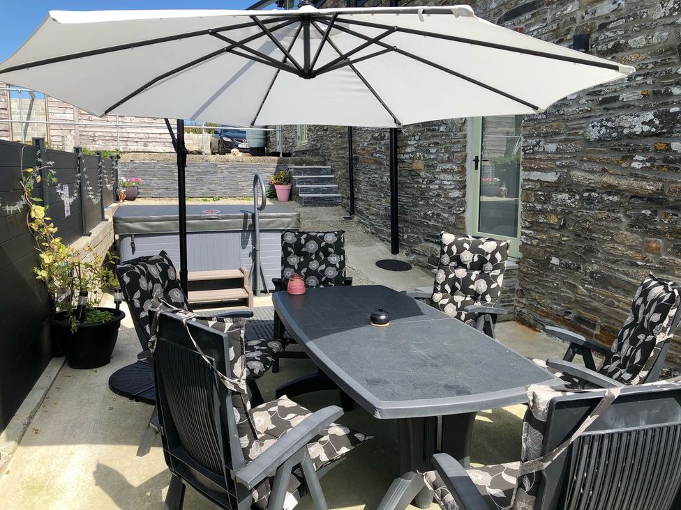 An outdoor seating area with a table and chairs at The Cartbarn at Cadwgan Farm near Whitland