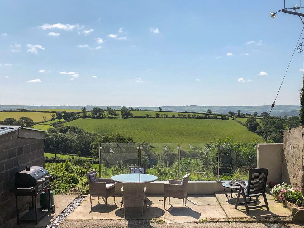 An outdoor seating area with a grill and table at The Cartbarn at Cadwgan Farm near Whitland