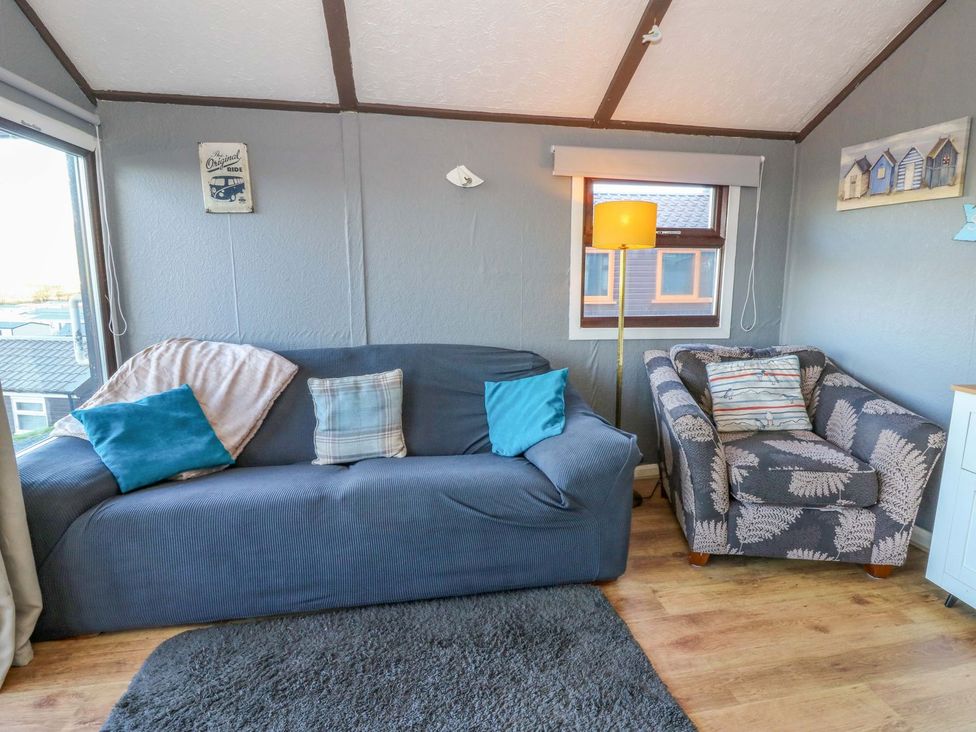 A snug with a sofa and armchair at Captain's Cabin in Clarach Bay near Aberystwyth
