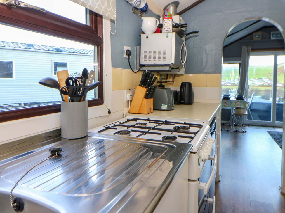 A kitchen with a stove and utensils at Captain's Cabin in Clarach Bay near Aberystwyth