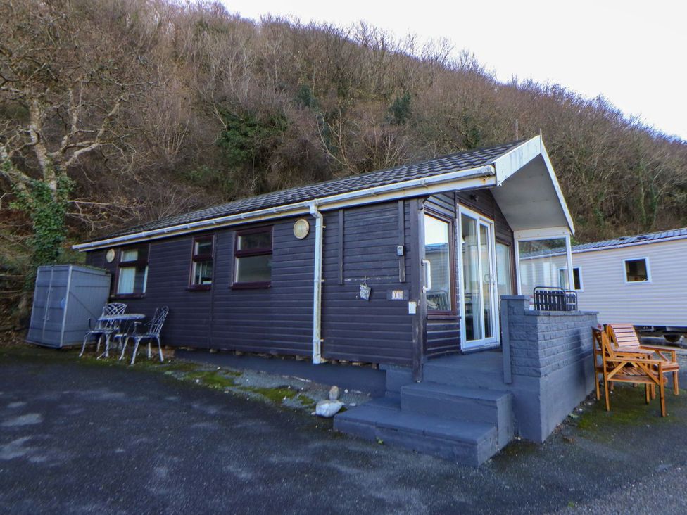 An outdoor view of a cabin with seating area at Captain's Cabin in Clarach Bay near Aberystwyth