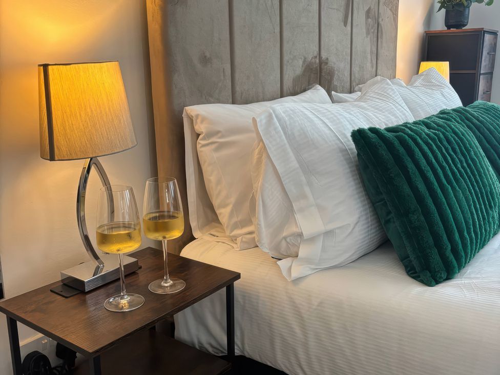A bedroom with a bed and glasses on a nightstand at Truly Scrumptious in Yarm
