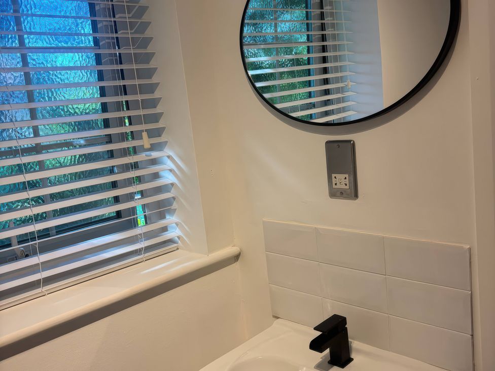A sink with a mirror and window in the bathroom at Truly Scrumptious Yarm