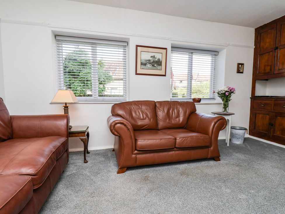A living room with a sofa and lamp at the Farmhouse in Whitby