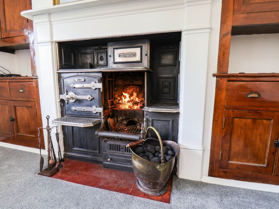 A kitchen with a stove and fireplace at the Farmhouse in Whitby