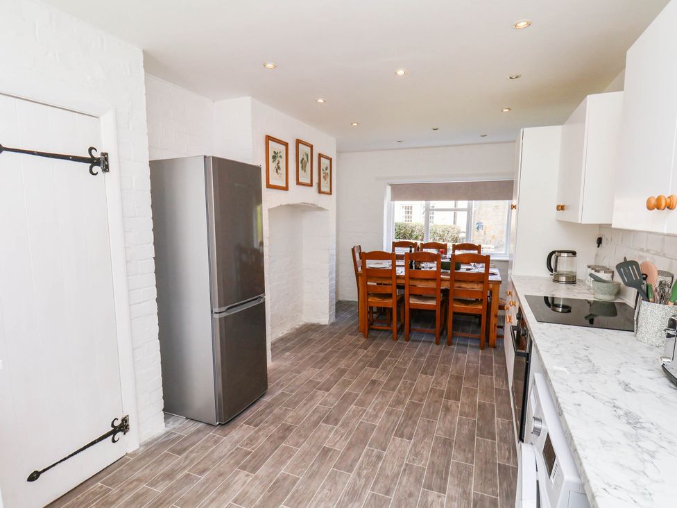 A kitchen with a dining area and a refrigerator at Farmhouse in Whitby