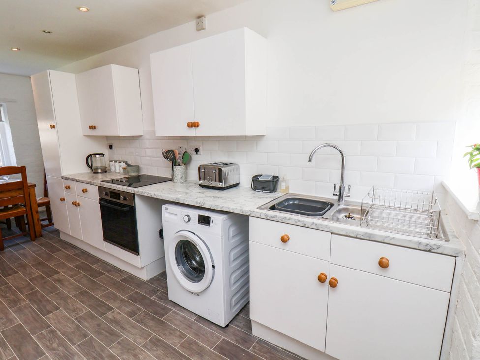A kitchen with cabinets, a sink, and appliances at the Farmhouse in Whitby