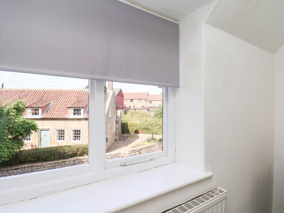 A window with a view of houses and garden at the Farmhouse in Whitby