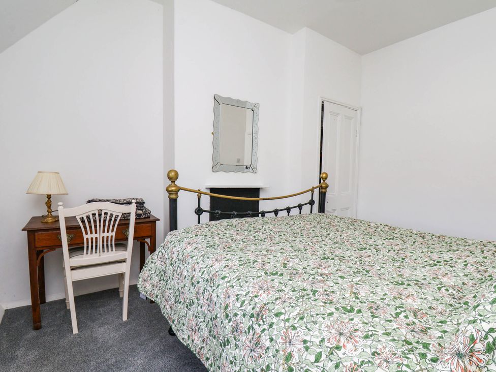 A bedroom with a bed and desk at the Farmhouse in Whitby