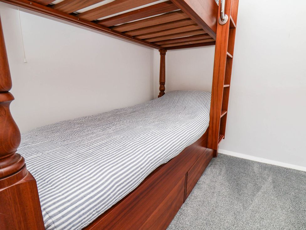 A bunk bed with a striped mattress at the Farmhouse in Whitby