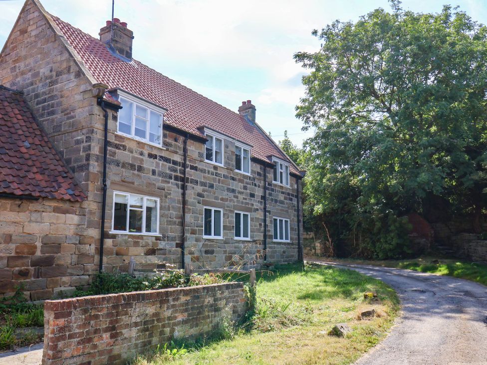 A stone house with windows and a driveway at Farmhouse in Whitby
