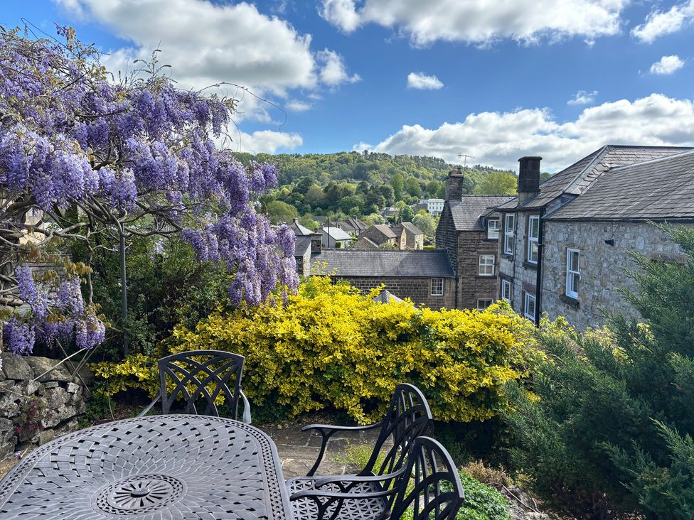 A garden view with wisteria and a table at The Brew House in Bakewell