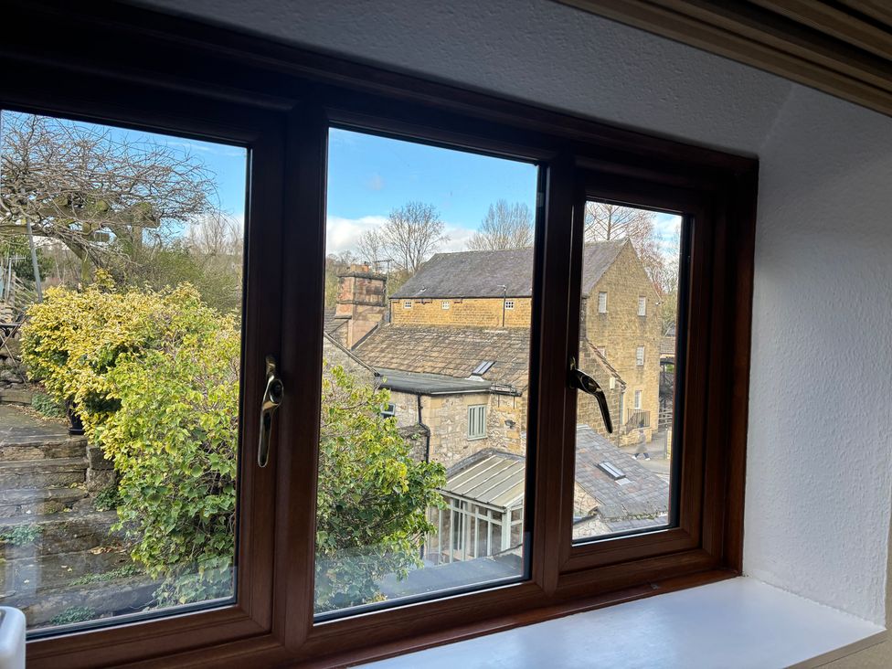A window view showing trees and buildings at The Brew House in Bakewell