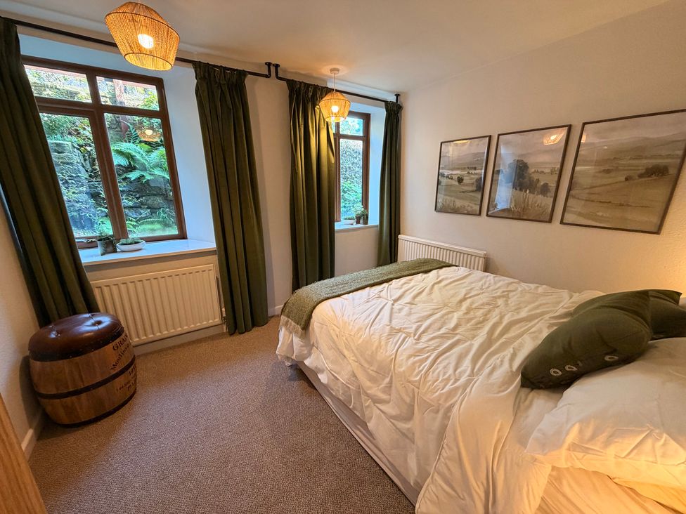 A bedroom with a bed and windows at The Brew House in Bakewell
