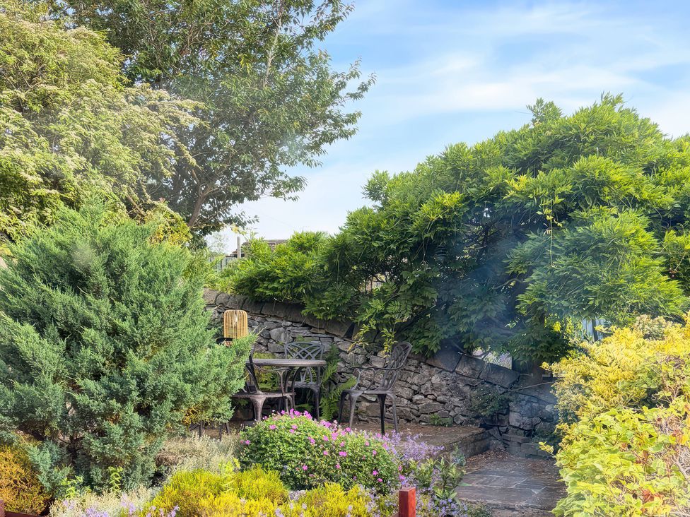 A garden with a table and chairs among plants at The Brew House in Bakewell