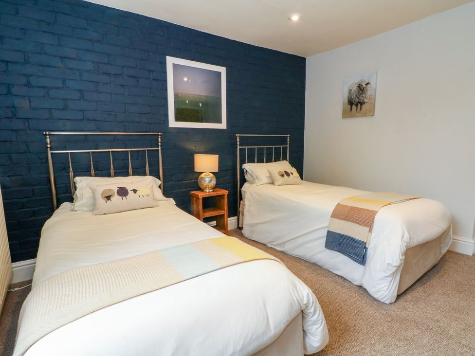 A bedroom with two single beds and a bedside table at The Brew House in Bakewell