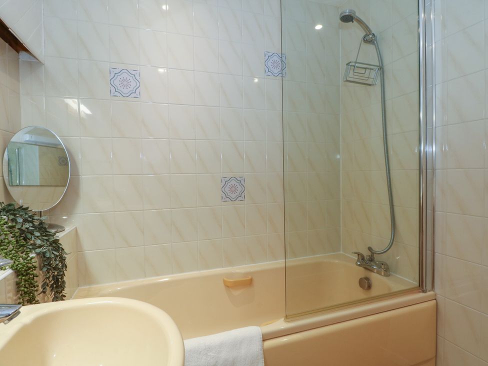 A bathroom with a bathtub, mirror, and sink at The Brew House in Bakewell