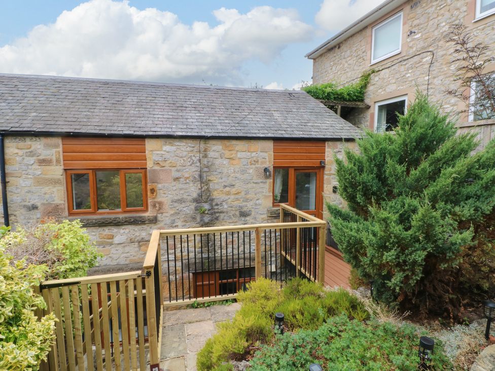 A garden view with stone buildings and greenery at The Brew House in Bakewell