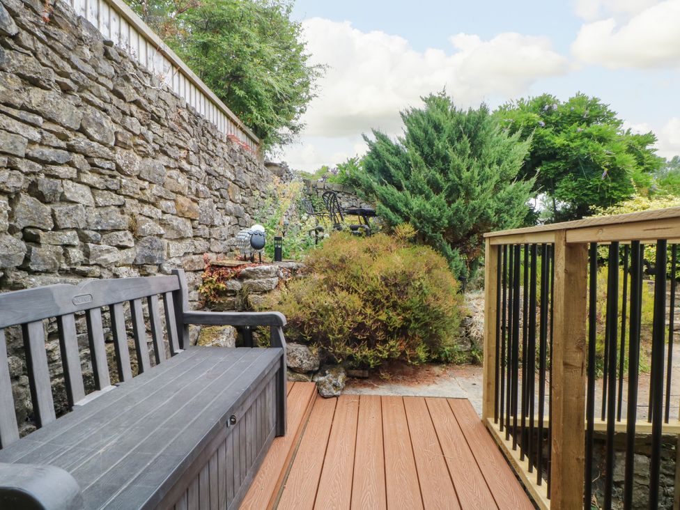 An outdoor space with a bench and stone wall at The Brew House in Bakewell