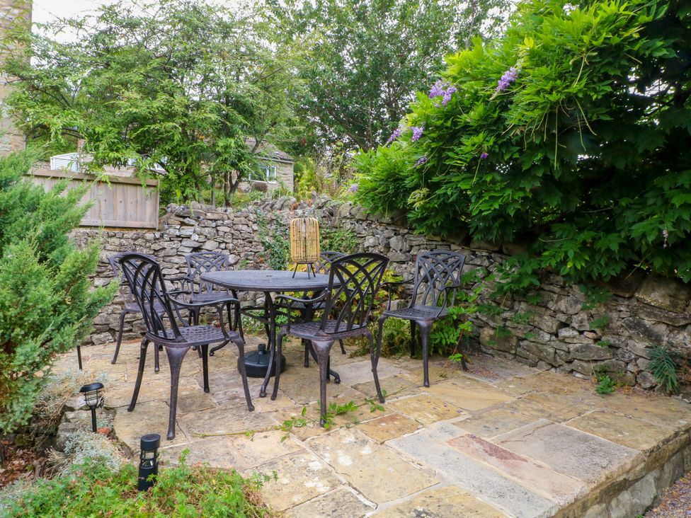 A garden with a table and chairs surrounded by stones at The Brew House in Bakewell