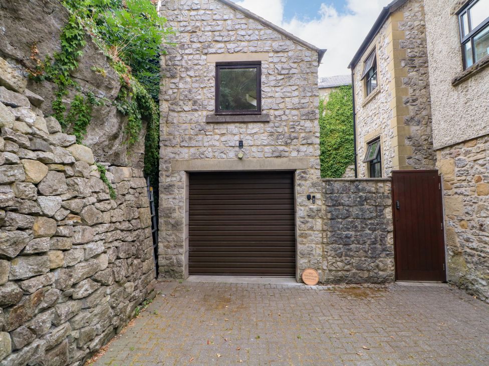 An outdoor view of a garage with stone walls at The Brew House in Bakewell
