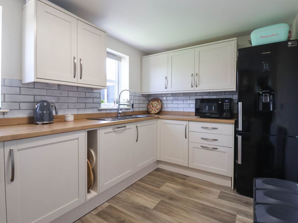 A kitchen with cabinets, appliances, and a sink at 3 Mill Lane with HT Grimsby