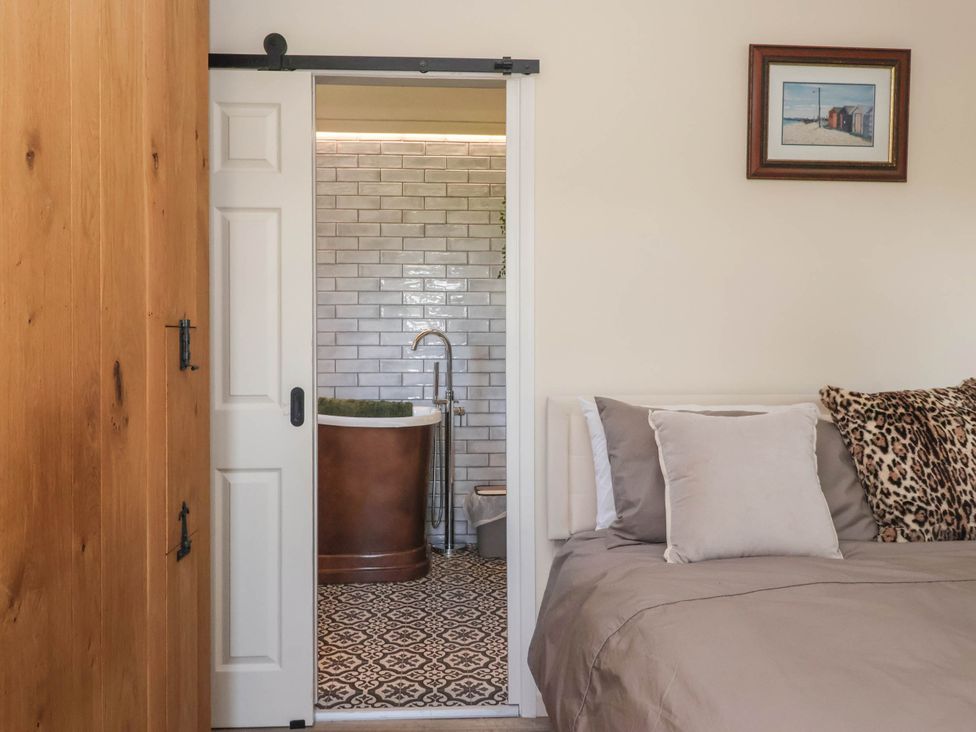 A bedroom with a bed and a door leading to a bathroom at 3 Mill Lane with HT Grimsby