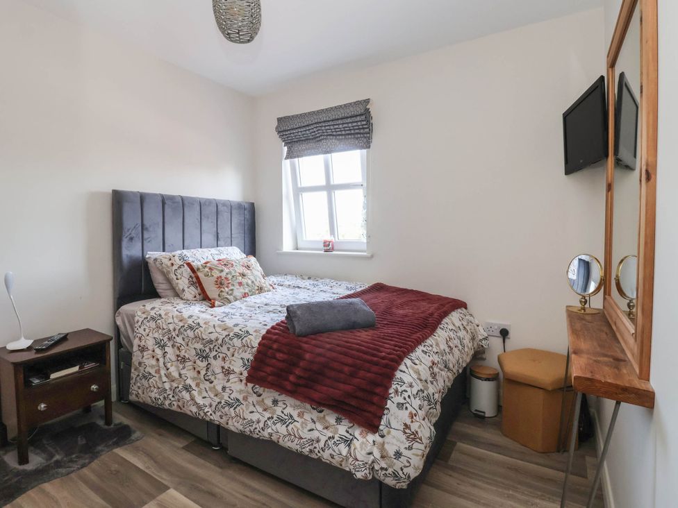 A bedroom with a bed and nightstand at 3 Mill Lane with HT in Grimsby