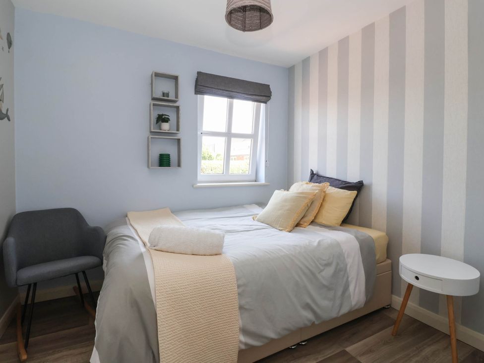 A bedroom with a bed and a chair at 3 Mill Lane with HT, Grimsby