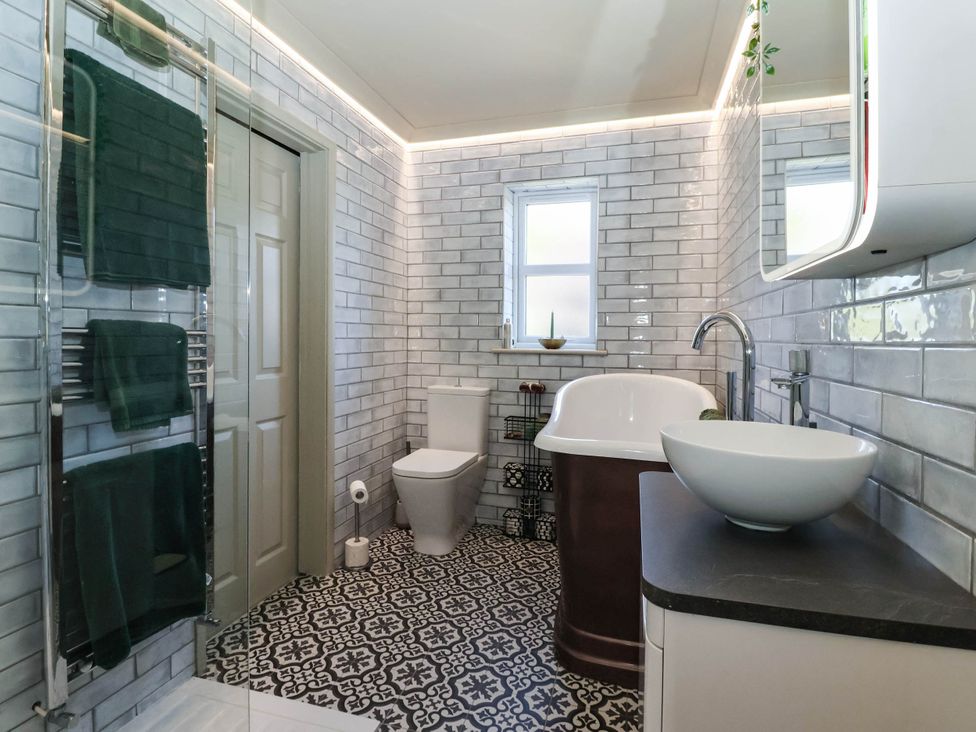 A bathroom with a bathtub and sink at 3 Mill Lane with HT in Grimsby