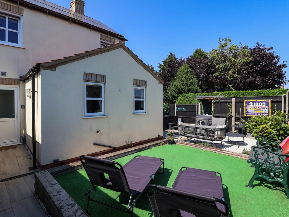 A garden with deck chairs and patio furniture at 3 Mill Lane with HT in Grimsby