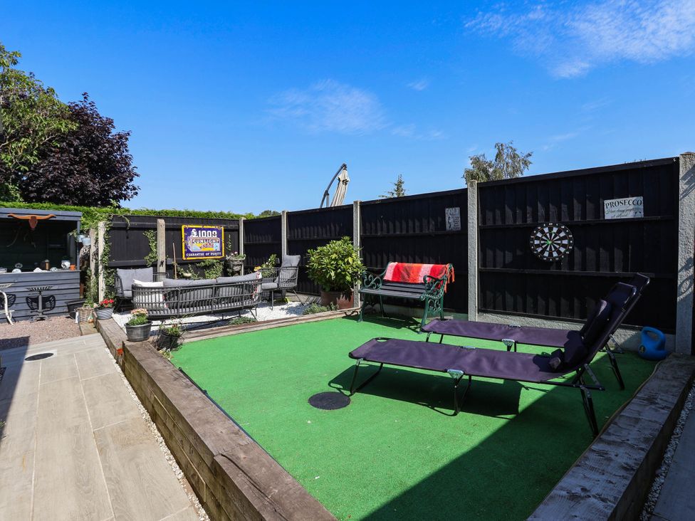 A garden with lounge chairs and a dartboard at 3 Mill Lane with HT in Grimsby