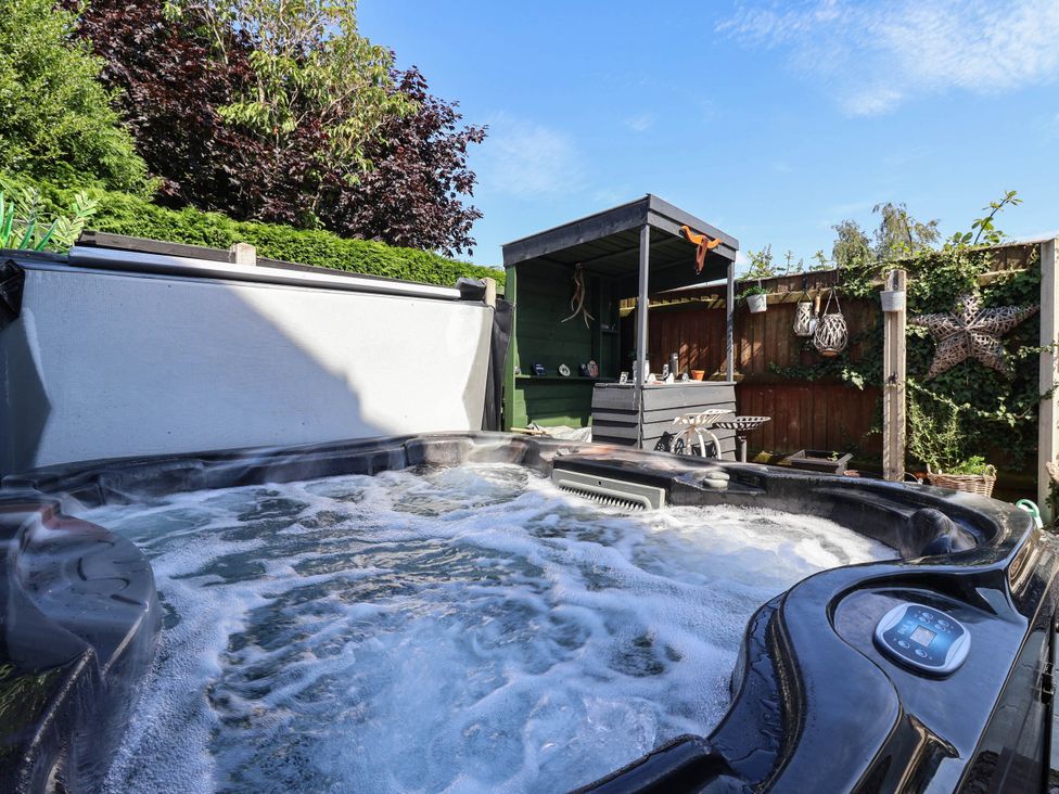 A hot tub with bubbling water near an outdoor bar at 3 Mill Lane with HT Grimsby
