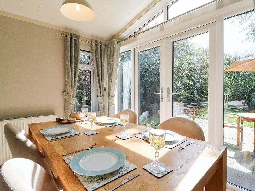 A dining room with a table set for meals at Oak Lodge Battisford near Stowmarket