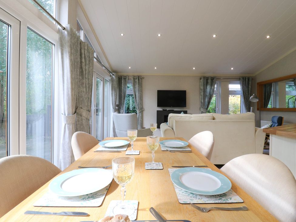 A dining room with a table and chairs at Oak Lodge Battisford near Stowmarket