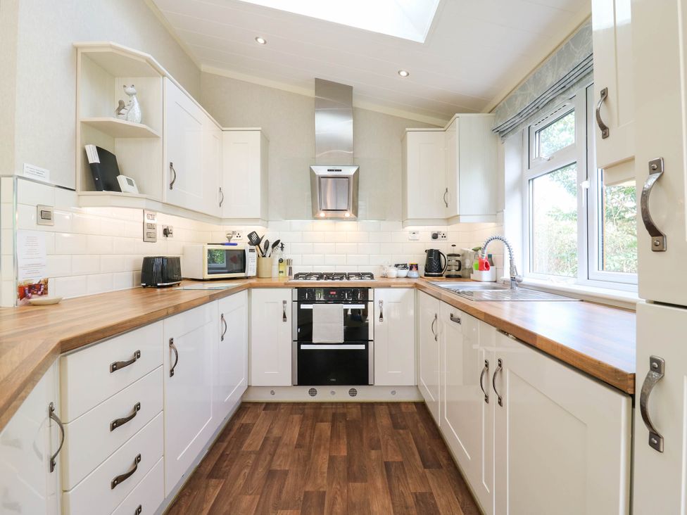 A kitchen with cabinets and appliances at Oak Lodge Battisford near Stowmarket