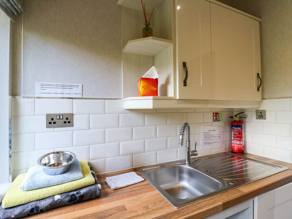 A kitchen with a sink and cabinets at Oak Lodge Battisford near Stowmarket