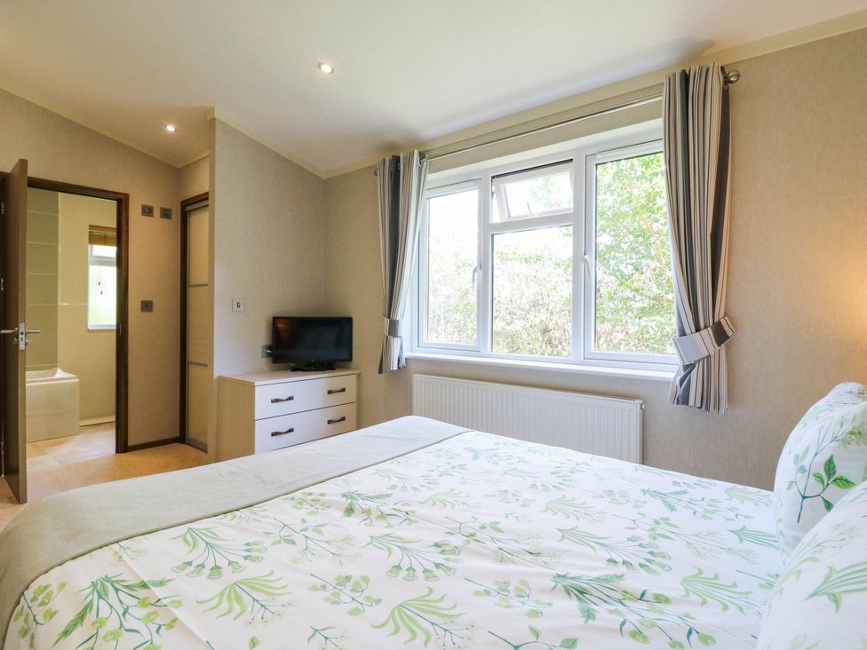 A bedroom with a bed and a television at Oak Lodge Battisford near Stowmarket